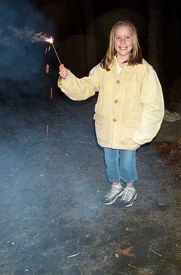Sarah with sparkler while camping at Pawtuckaway State Park in May 2003.