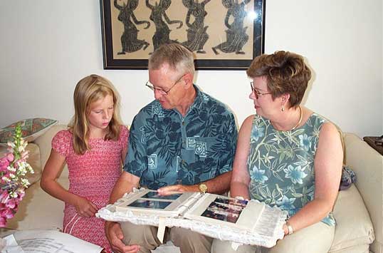 Sarah, Doss and Candy looking at a photo album in Virginia.