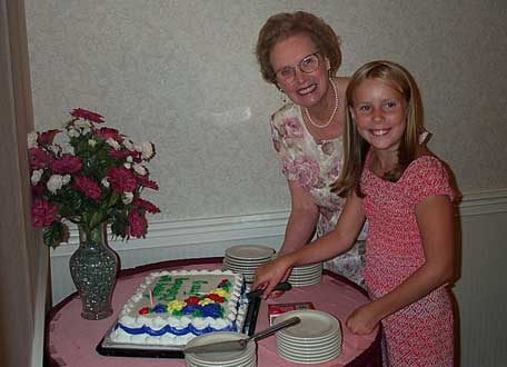 Sarah helping Grandma Jenny cut her cake.